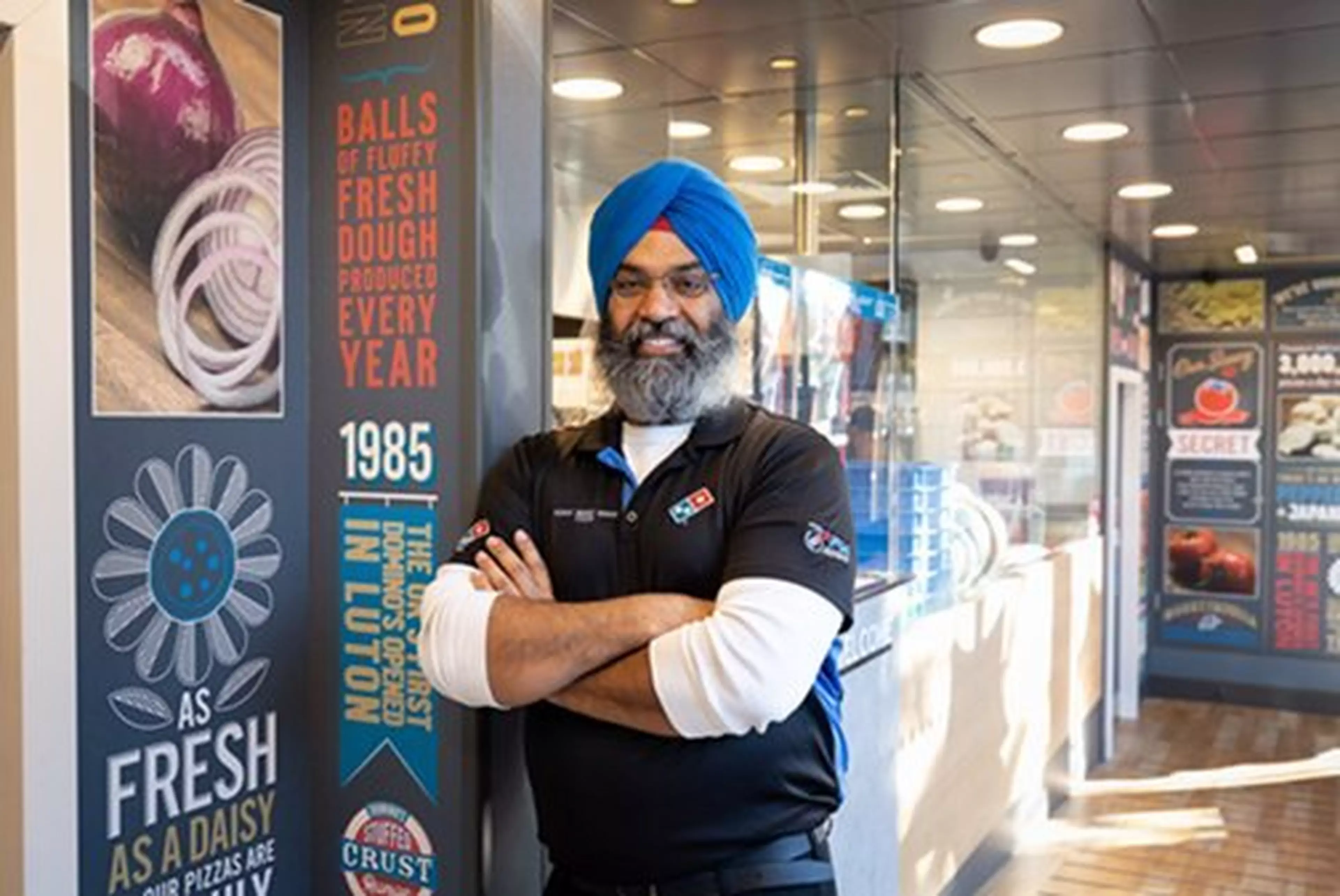 A domino's home grown hero standing in his branch