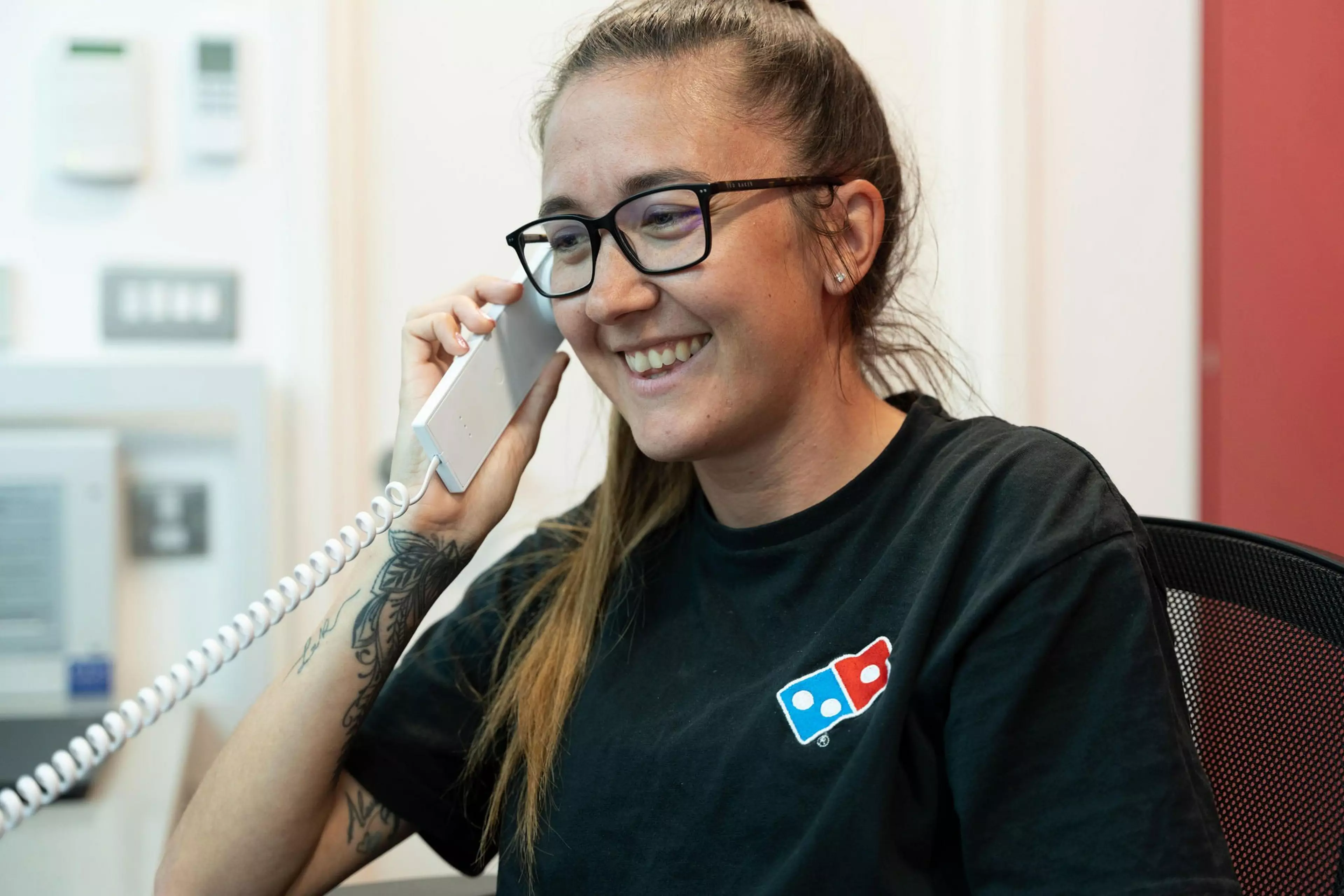 A Domino's employee picking up a pizza on her peel