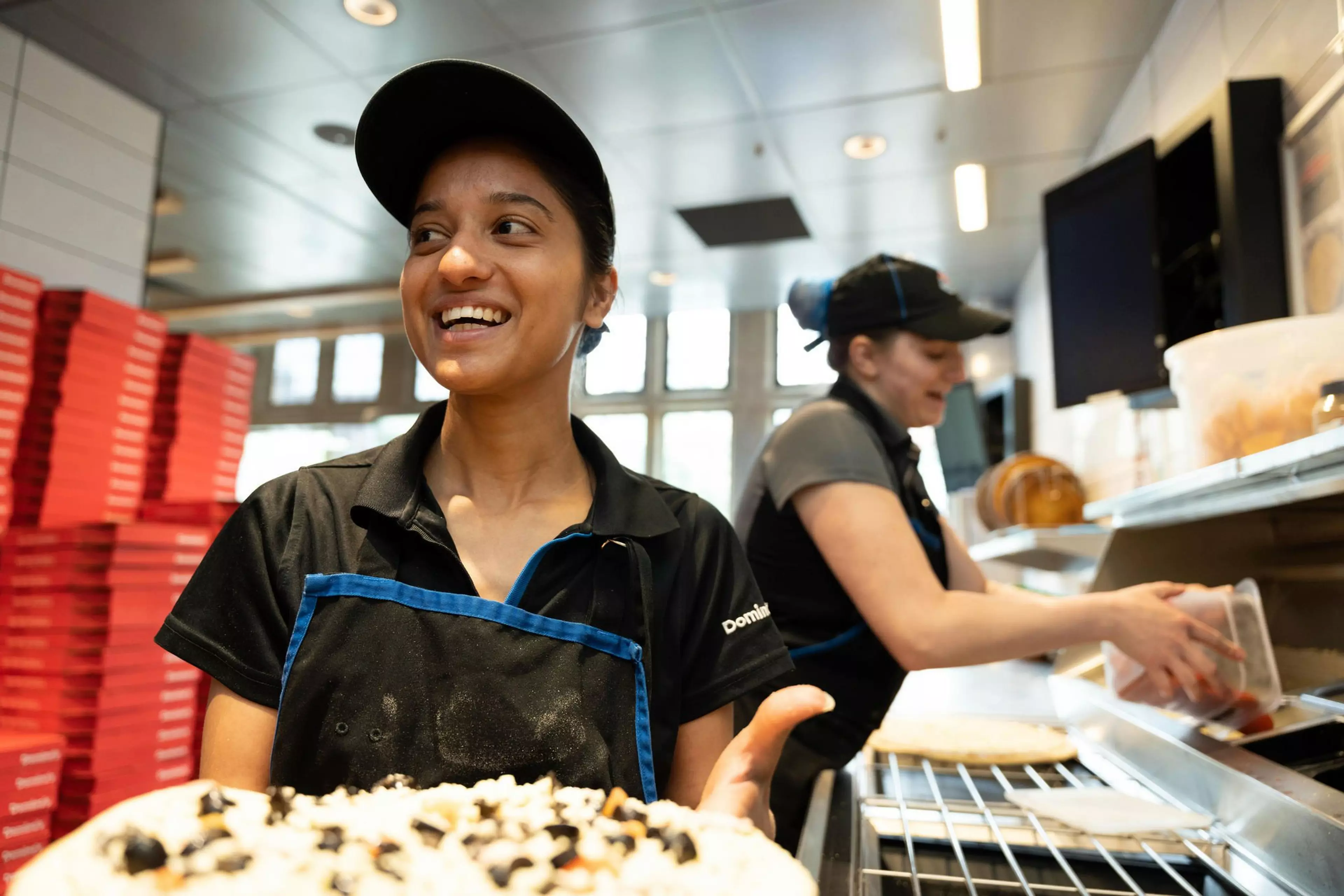 Dominos work making pizza