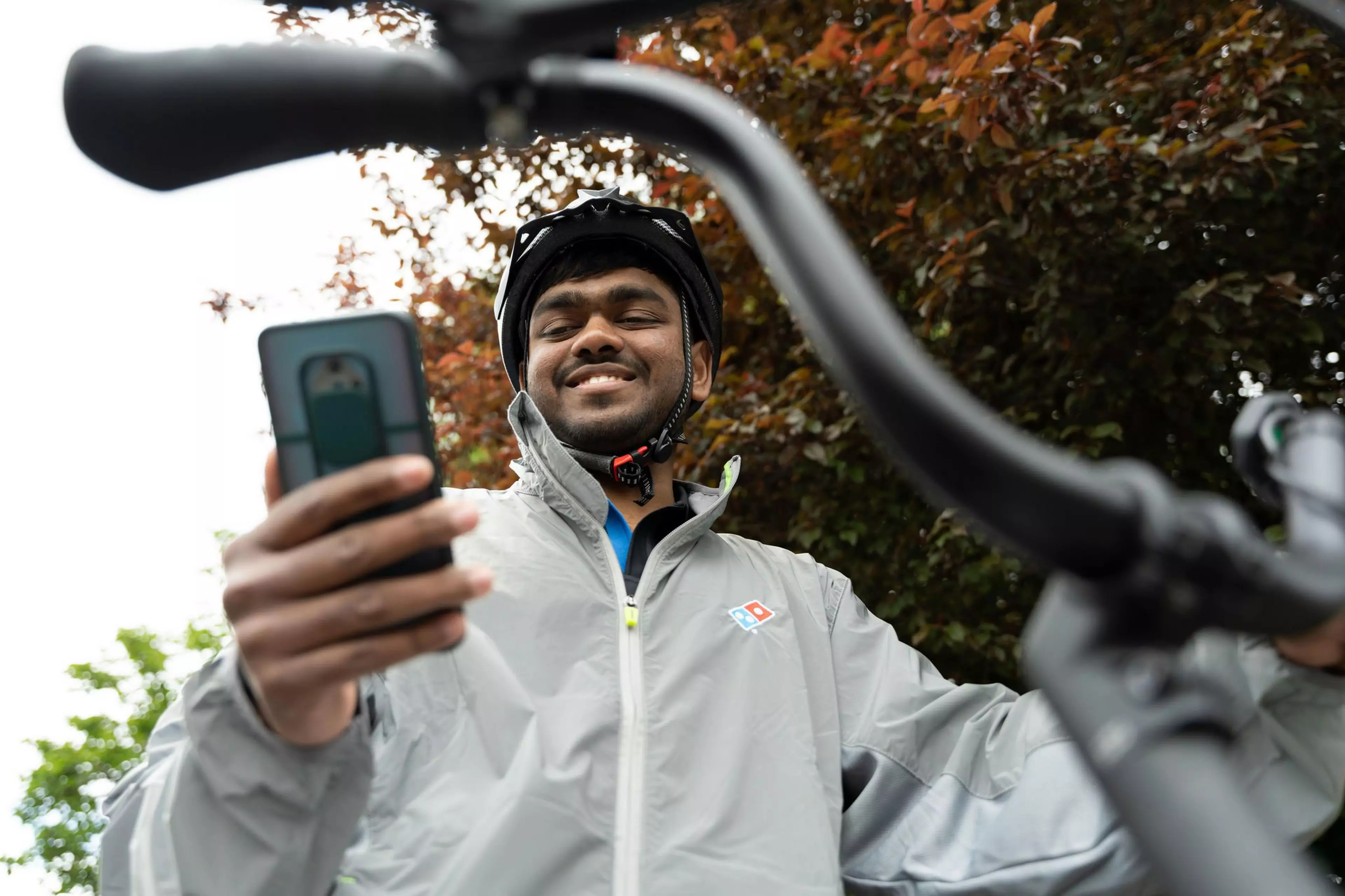 Domino's delivery man looking at phone at the app