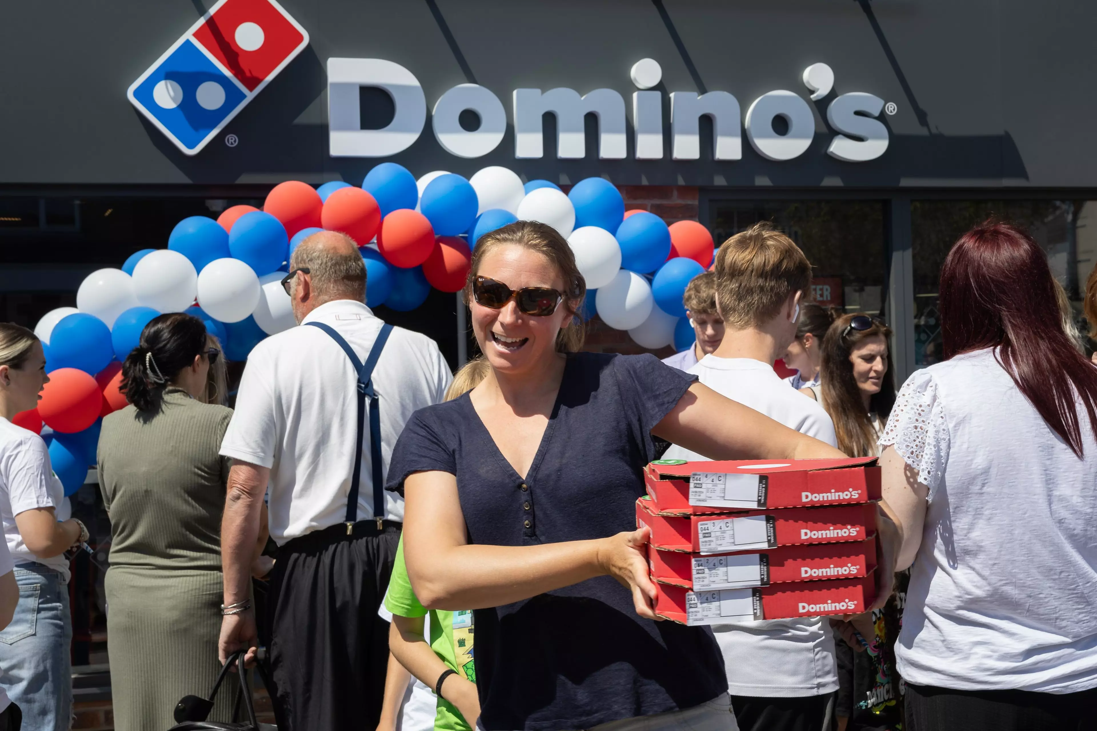 A woman purchasing a pizza in store